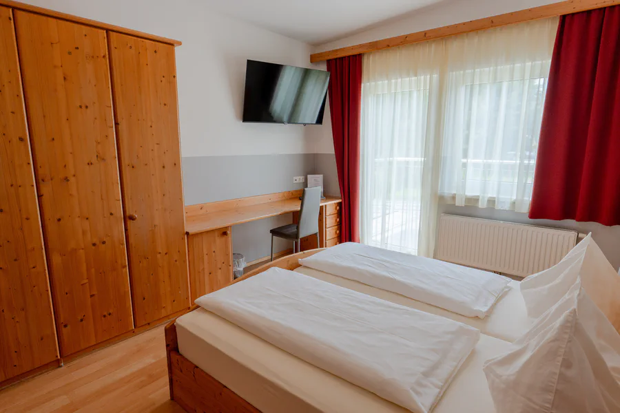 Zimmer mit Bett, Fernseher und Fenster